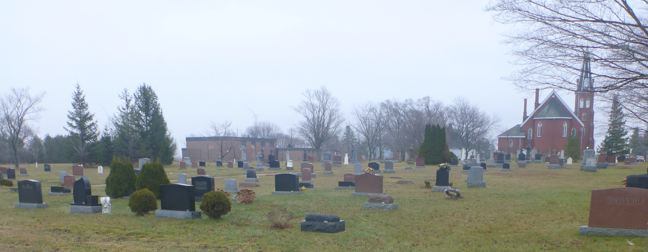 A misty image of a large historic cemetery. An historic church is visible in the background