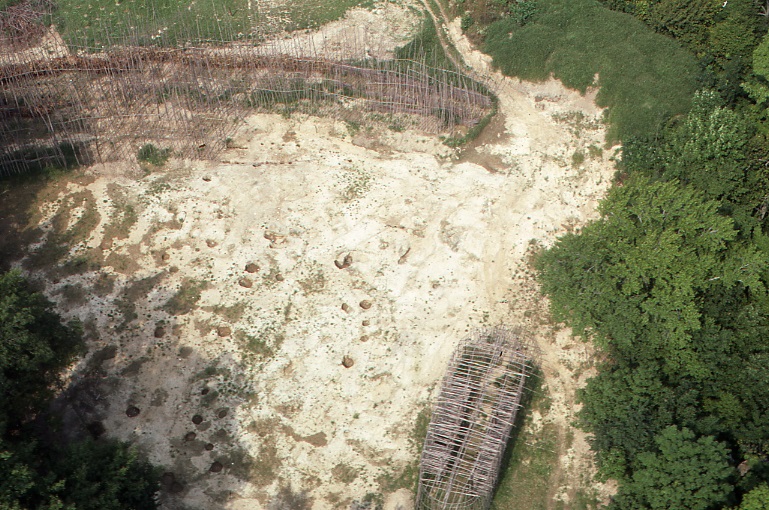 A 1980 aerial of the reconstruction of the Lawson Village. The longhouse and palisade are visible. Multiple pits and excavations are also visible