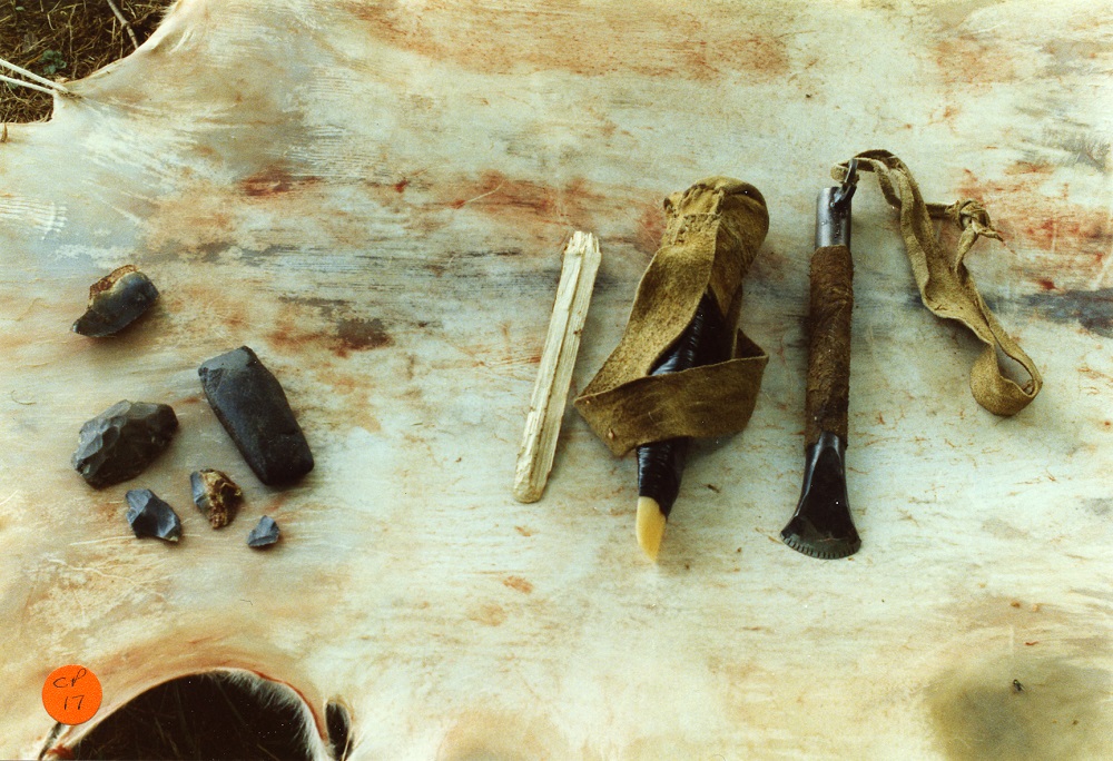 A traditional Hide Tanning kit laid out on a stretched hide. Stone and bones tools and implements are shown, some are hafted or wrapped in leather. Hide Tanning with Morgan Baillargeon and Paul Lennox - 1989