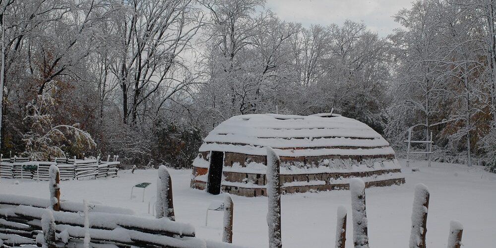 A snow-covered longhouse is visible in this 2008 image. The foreground maze is also covered in snow as are the trees in the background