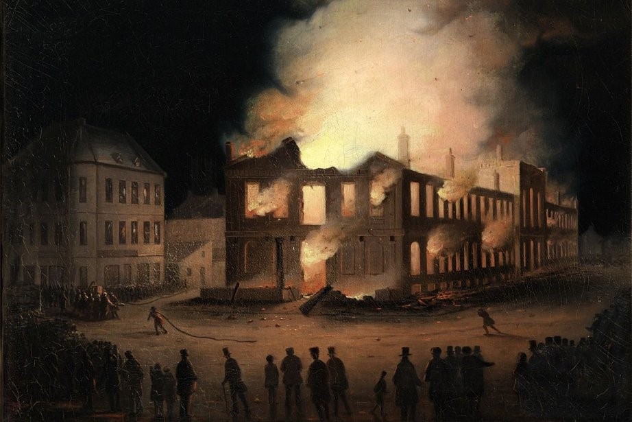 A painting showing the Burning of the Parliament Building in Montreal by Joseph Légaré. A large building is shown on fire in the night. A fire brigade is attempting to pumup water to fight the fire while onlookers ring the scene. Neighbouring buildings are lit up by the flames.