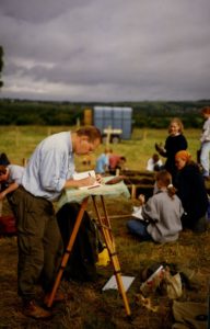 Charles Orser Jr. makes notes in the foreground while students talk and work on a block excavation in the background
