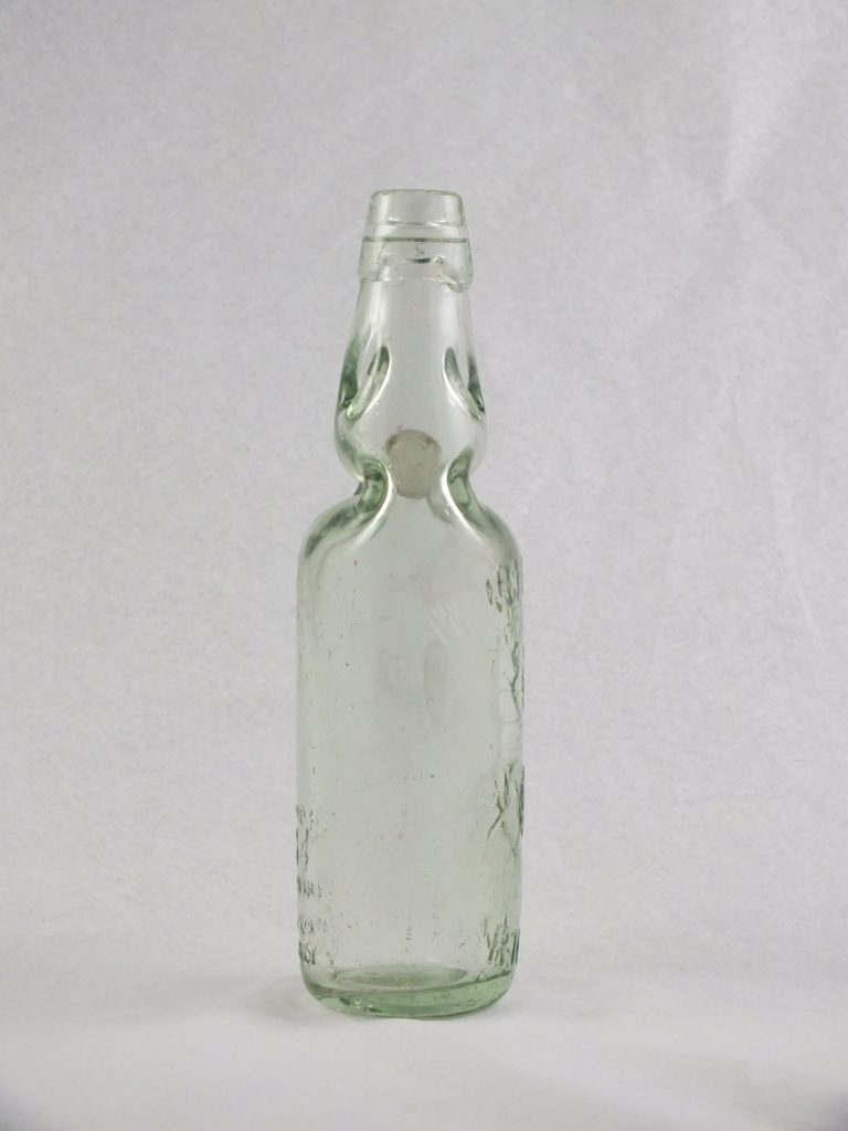 An intact clear Codd Bottle artifact showing the narrow neck and glass bead inside.
